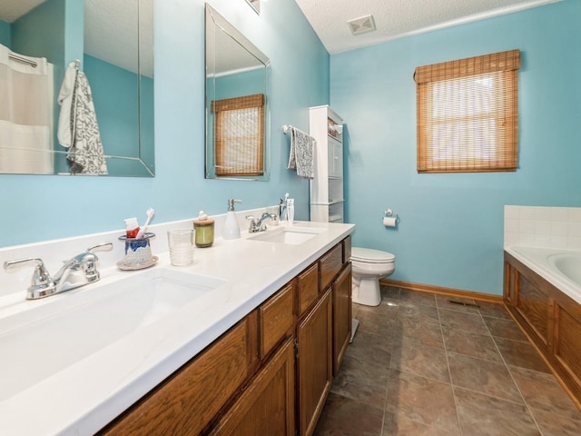 2190 NW 147th St, Clive, IA 50325 - bathroom with a bath, toilet, double vanity, a textured ceiling, and baseboards