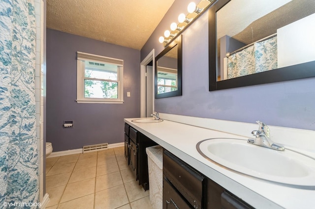 1223 Cherry Pkwy, Norwalk, IA 50211 - full bathroom with double vanity, baseboards, toilet, tile patterned floors, and a textured ceiling