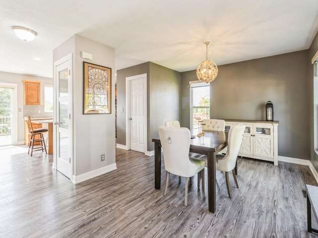900 SE Woodbine Dr, Grimes, IA 50111 - dining area with wood finished floors, baseboards, a chandelier, and healthy amount of natural light