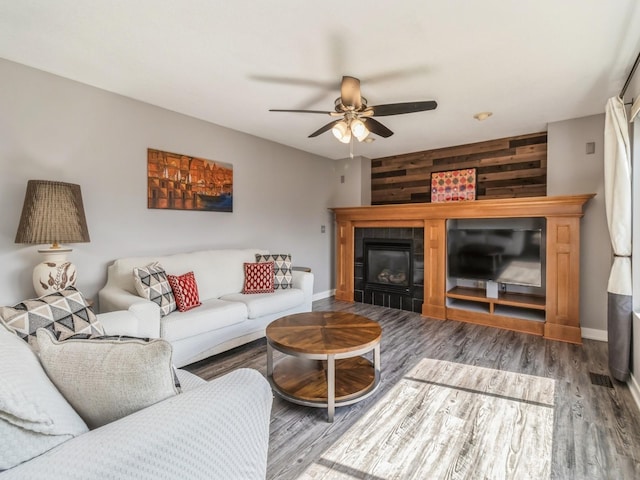 900 SE Woodbine Dr, Grimes, IA 50111 - living area with a ceiling fan, wood finished floors, a fireplace, baseboards, and wooden walls