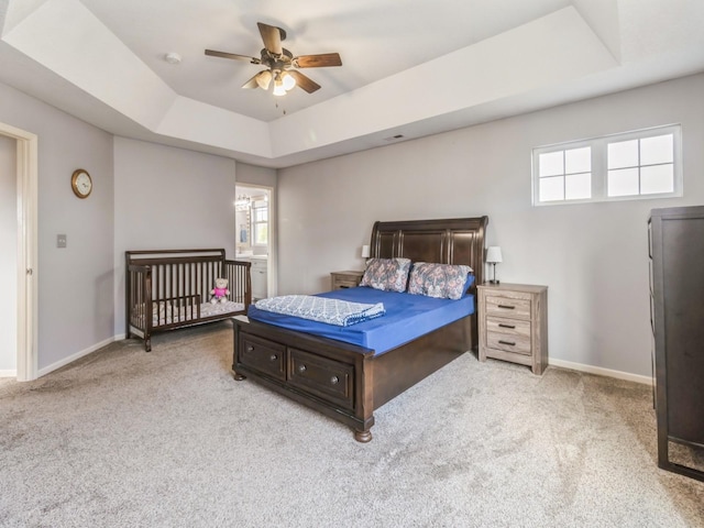 900 SE Woodbine Dr, Grimes, IA 50111 - carpeted bedroom featuring a raised ceiling, multiple windows, baseboards, and ceiling fan