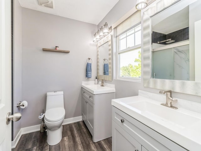 900 SE Woodbine Dr, Grimes, IA 50111 - full bathroom featuring toilet, two vanities, wood finished floors, a shower, and baseboards