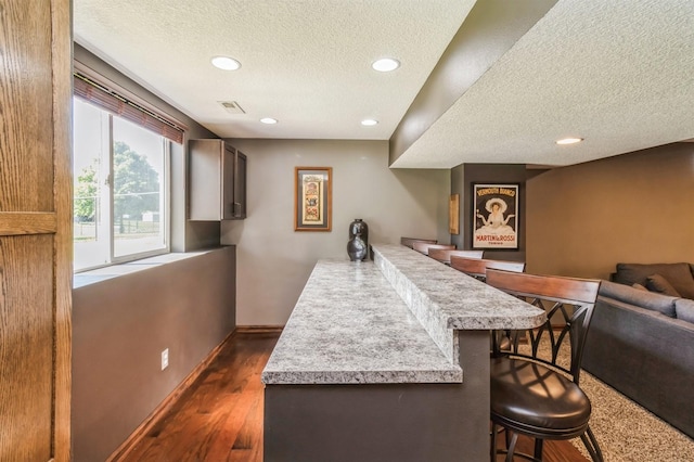 900 SE Woodbine Dr, Grimes, IA 50111 - bar area featuring a textured ceiling, recessed lighting, dark wood-style flooring, and baseboards