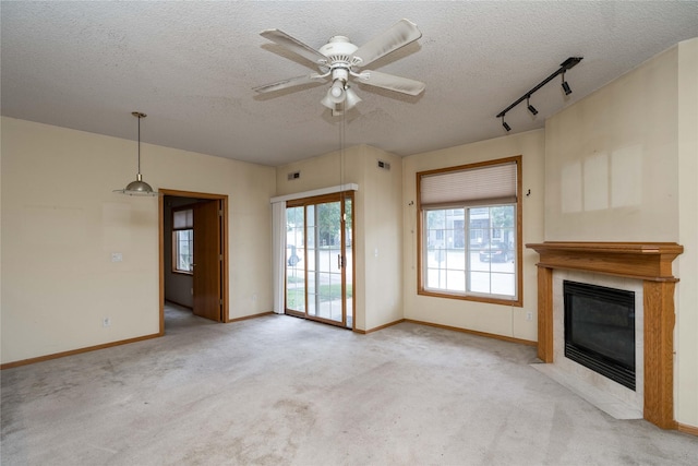 2433 Patricia Dr Unit 24, Urbandale, IA 50322 - unfurnished living room featuring a textured ceiling, carpet flooring, a fireplace, ceiling fan, and track lighting