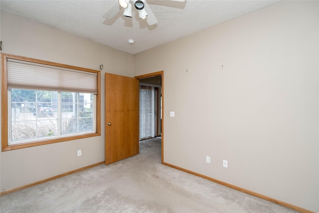 2433 Patricia Dr Unit 24, Urbandale, IA 50322 - carpeted empty room with baseboards, a ceiling fan, a textured ceiling, and a smoke detector