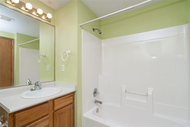 2433 Patricia Dr Unit 24, Urbandale, IA 50322 - bathroom featuring washtub / shower combination, vanity, and a textured ceiling