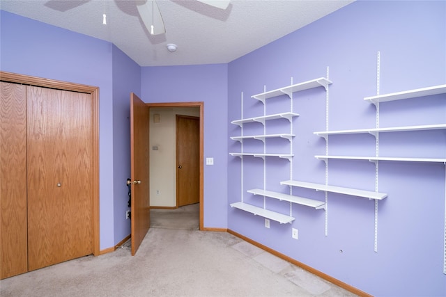 2433 Patricia Dr Unit 24, Urbandale, IA 50322 - unfurnished bedroom with carpet, baseboards, a textured ceiling, a closet, and a ceiling fan