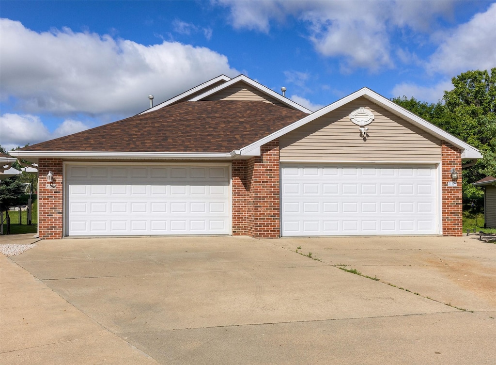 709 Kitterman Cir, Norwalk, IA 50211 - ranch-style home with driveway, brick siding, a garage, and a shingled roof