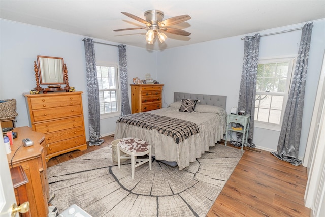 620 W Filmore St, Winterset, IA 50273 - bedroom with wood finished floors, baseboards, and a ceiling fan
