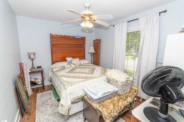 620 W Filmore St, Winterset, IA 50273 - bedroom featuring wood finished floors, a textured ceiling, and a ceiling fan