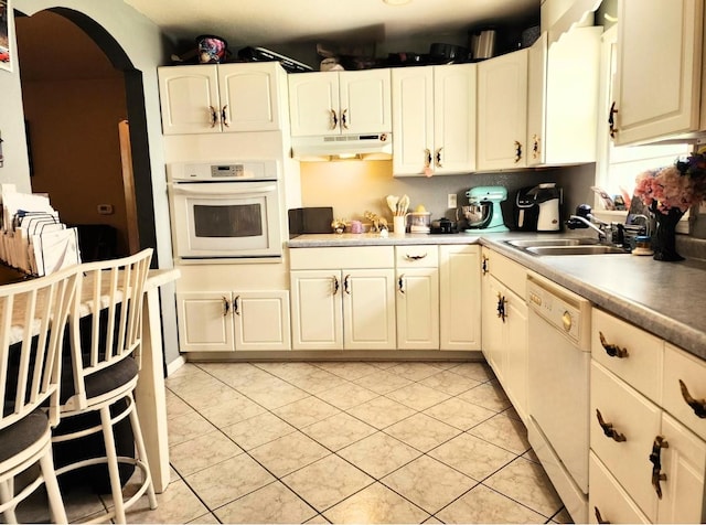 1420 Court Ave, Chariton, IA 50049 - kitchen featuring white appliances, under cabinet range hood, a sink, arched walkways, and light tile patterned flooring