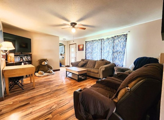 1420 Court Ave, Chariton, IA 50049 - living area with wood finished floors, a ceiling fan, and a textured ceiling