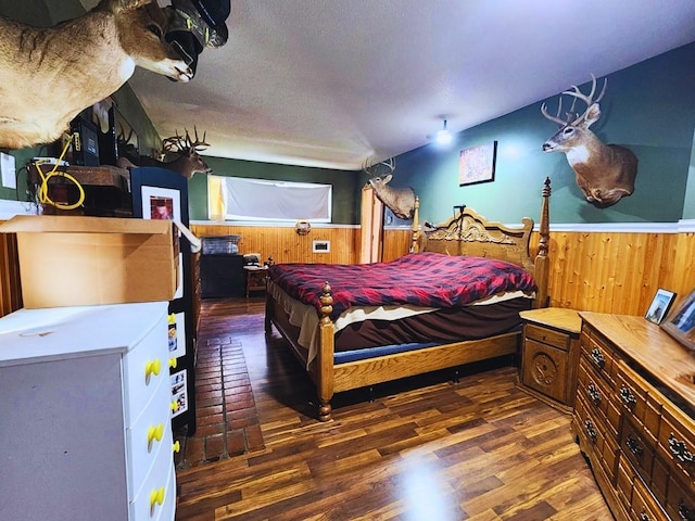 1420 Court Ave, Chariton, IA 50049 - bedroom with wooden walls, wood finished floors, a wainscoted wall, and a textured ceiling