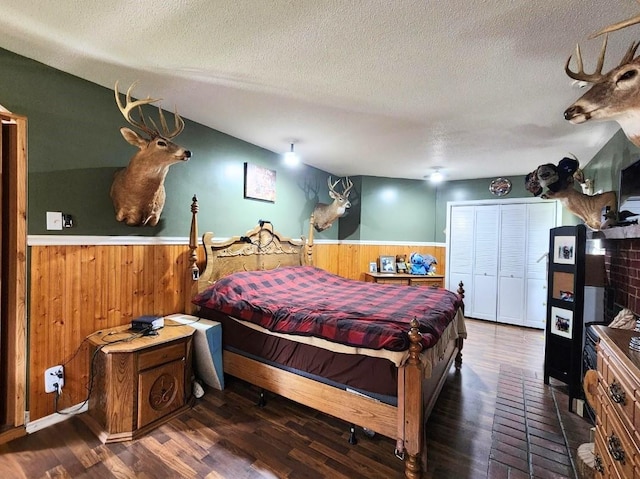 1420 Court Ave, Chariton, IA 50049 - bedroom with a wainscoted wall, wooden walls, a textured ceiling, and wood finished floors