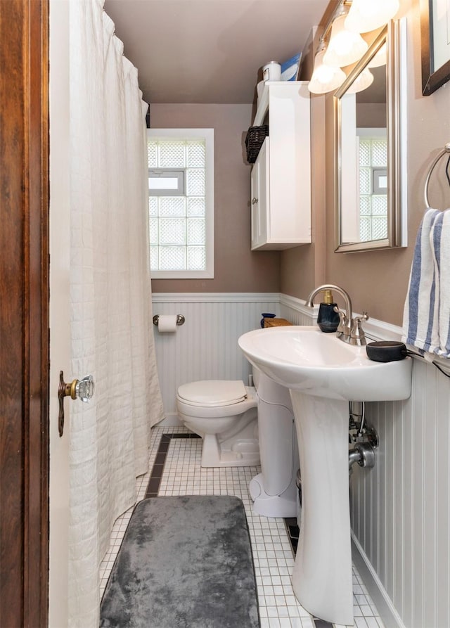 2118 34th St, Des Moines, IA 50310 - full bath with toilet, wainscoting, tile patterned floors, healthy amount of natural light, and a shower with curtain