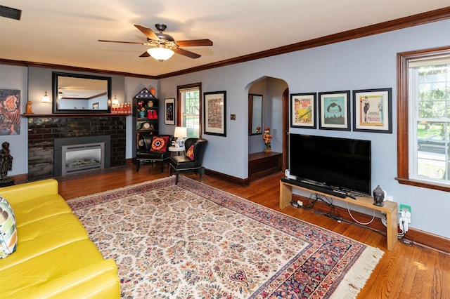 2118 34th St, Des Moines, IA 50310 - living area featuring arched walkways, baseboards, a ceiling fan, wood finished floors, and crown molding