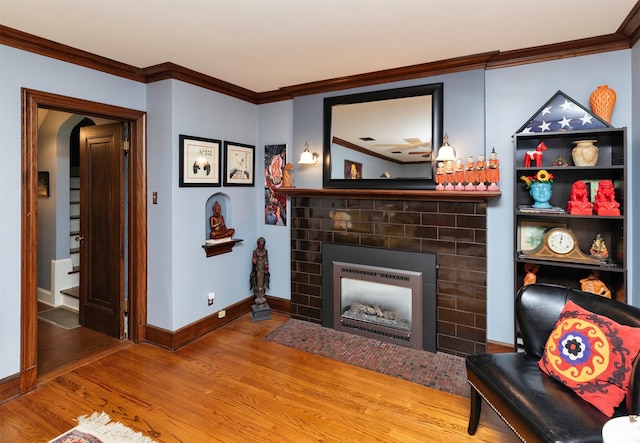 2118 34th St, Des Moines, IA 50310 - living room with wood finished floors, crown molding, a fireplace with flush hearth, and baseboards