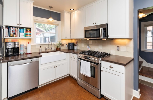 2118 34th St, Des Moines, IA 50310 - kitchen with appliances with stainless steel finishes, dark countertops, a sink, and decorative backsplash