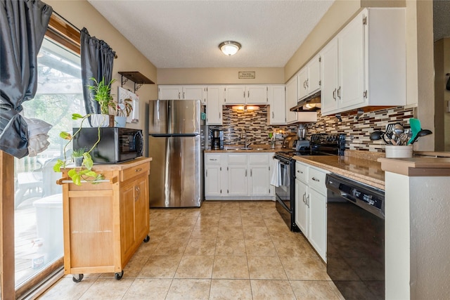 1903 W 5th Ave, Indianola, IA 50125 - kitchen featuring black appliances, under cabinet range hood, backsplash, healthy amount of natural light, and a textured ceiling