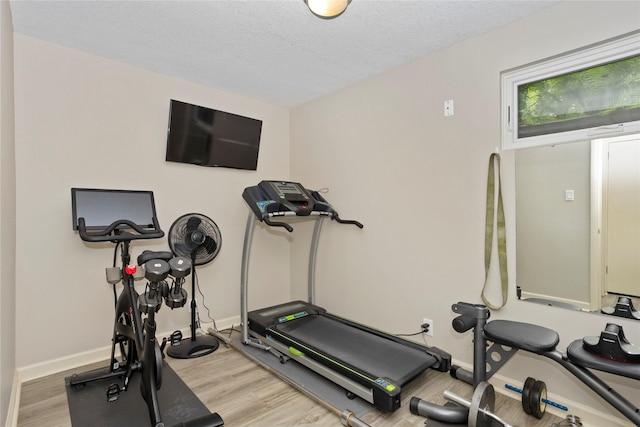 2740 Forest Dr, Des Moines, IA 50312 - workout room featuring wood finished floors, baseboards, and a textured ceiling