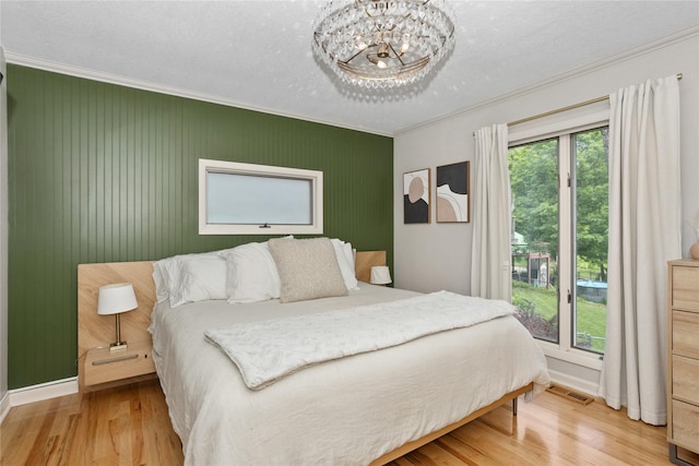 2740 Forest Dr, Des Moines, IA 50312 - bedroom with wood finished floors, ornamental molding, baseboards, and a chandelier