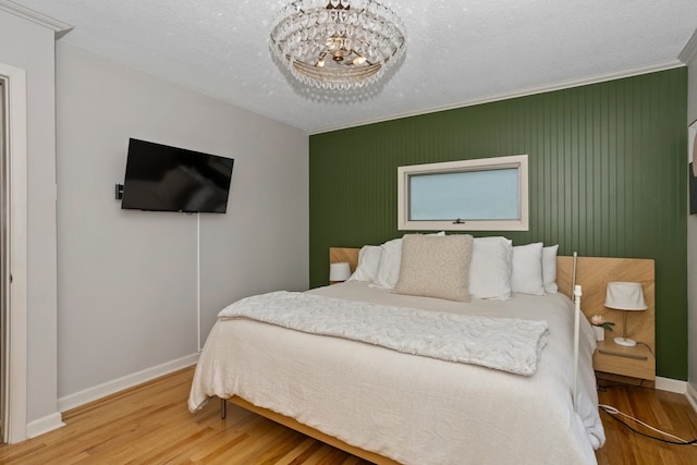 2740 Forest Dr, Des Moines, IA 50312 - bedroom with baseboards, wood finished floors, a chandelier, and ornamental molding