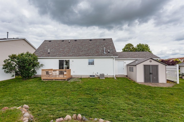 310 NE Meadowlark Ln, Waukee, IA 50263 - back of house featuring a wooden deck, a storage unit, a lawn, and roof with shingles