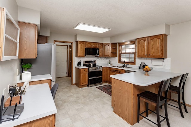 310 NE Meadowlark Ln, Waukee, IA 50263 - kitchen with appliances with stainless steel finishes, open shelves, a peninsula, decorative backsplash, and a textured ceiling