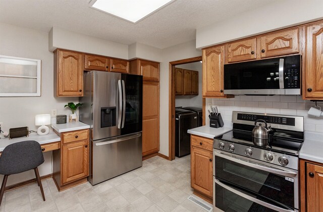 310 NE Meadowlark Ln, Waukee, IA 50263 - kitchen featuring stainless steel appliances, washing machine and clothes dryer, light countertops, backsplash, and brown cabinets