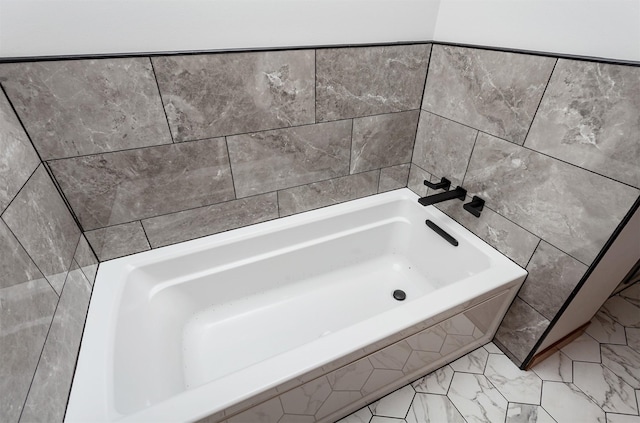 310 NE Meadowlark Ln, Waukee, IA 50263 - bathroom with a tub, tile walls, and marble finish floors