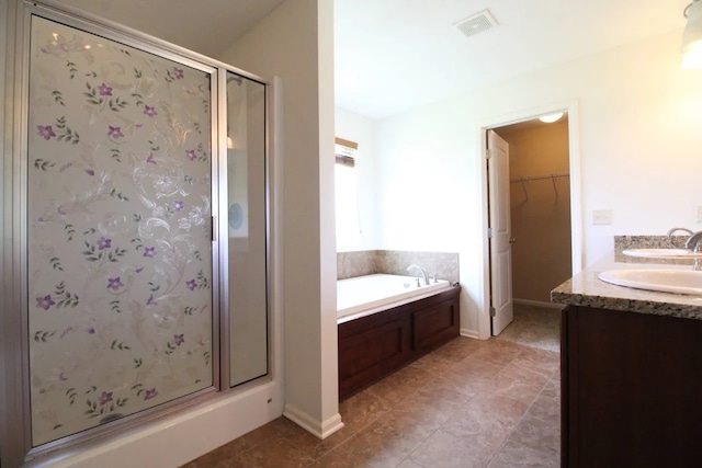 180 Bridgewood Dr, West Des Moines, IA 50266 - full bath with a shower stall, a bath, double vanity, a walk in closet, and tile patterned flooring