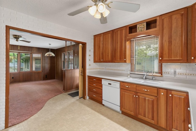 2700 Dosh Rd, Des Moines, IA 50310 - kitchen featuring dishwasher, ceiling fan, a sink, light countertops, and brown cabinetry