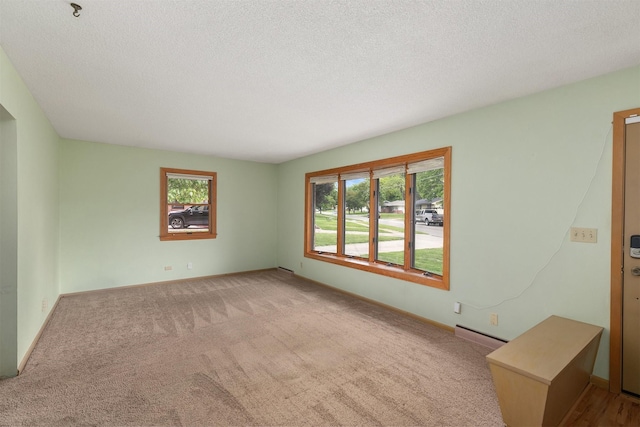 2700 Dosh Rd, Des Moines, IA 50310 - carpeted spare room featuring a textured ceiling, a baseboard heating unit, and baseboards