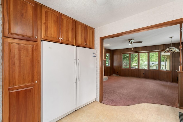 2700 Dosh Rd, Des Moines, IA 50310 - kitchen with freestanding refrigerator, a ceiling fan, brown cabinetry, open floor plan, and light colored carpet