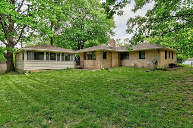 2700 Dosh Rd, Des Moines, IA 50310 - rear view of property featuring a chimney, a lawn, brick siding, and central AC unit