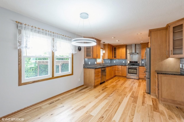 4337 Park Ct, Urbandale, IA 50322 - kitchen featuring stainless steel appliances, wall chimney exhaust hood, brown cabinetry, a sink, and light wood-style flooring