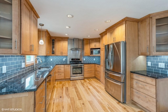 4337 Park Ct, Urbandale, IA 50322 - kitchen with appliances with stainless steel finishes, a sink, wall chimney exhaust hood, light wood-type flooring, and tasteful backsplash