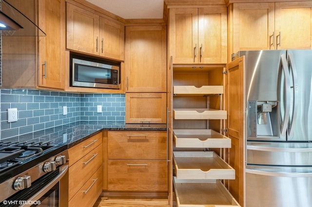4337 Park Ct, Urbandale, IA 50322 - kitchen featuring appliances with stainless steel finishes, tasteful backsplash, dark stone countertops, brown cabinetry, and extractor fan