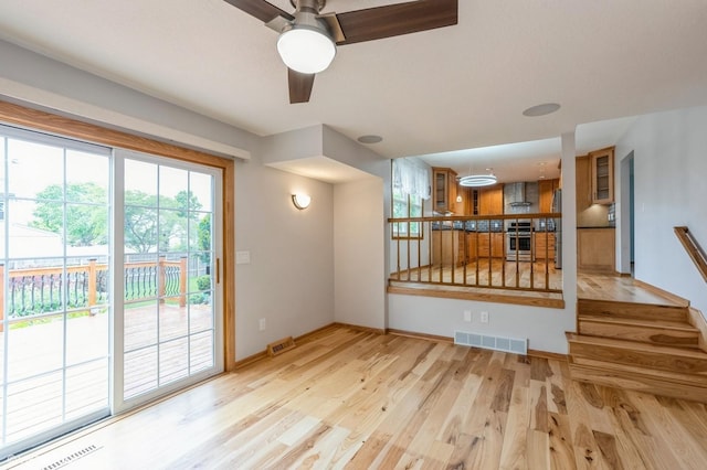 4337 Park Ct, Urbandale, IA 50322 - unfurnished living room with light wood finished floors, a ceiling fan, plenty of natural light, and baseboards