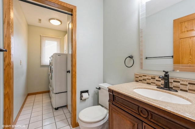 4337 Park Ct, Urbandale, IA 50322 - bathroom featuring vanity, toilet, washer / dryer, tile patterned flooring, and baseboards