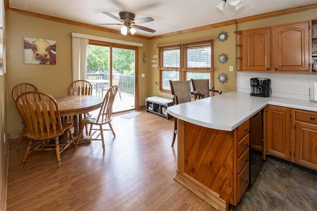3919 69th St, Urbandale, IA 50322 - kitchen with ceiling fan, crown molding, light countertops, a peninsula, and dark wood-style flooring
