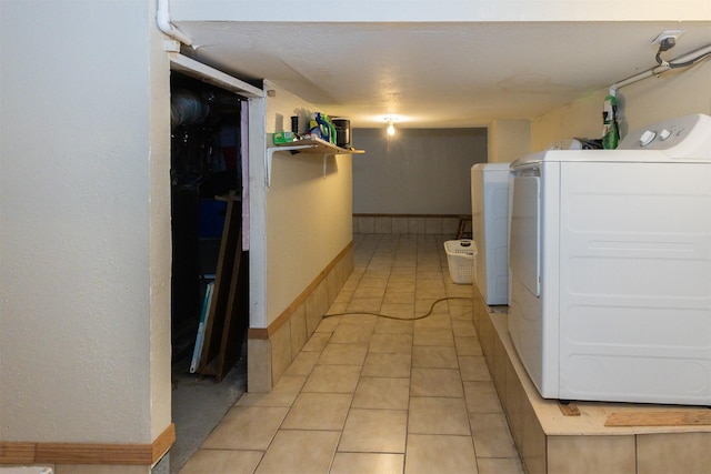 3919 69th St, Urbandale, IA 50322 - washroom featuring washing machine and dryer, light tile patterned floors, and baseboards