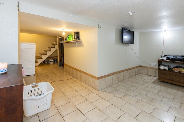 3919 69th St, Urbandale, IA 50322 - finished basement with stairs, light tile patterned flooring, and baseboards