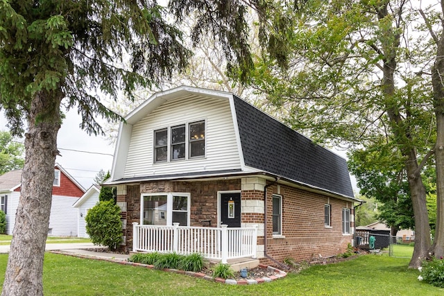 3919 69th St, Urbandale, IA 50322 - dutch colonial featuring a shingled roof, a gambrel roof, brick siding, and covered porch