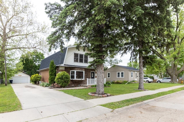 3919 69th St, Urbandale, IA 50322 - dutch colonial featuring an outbuilding, brick siding, a front lawn, a detached garage, and roof with shingles