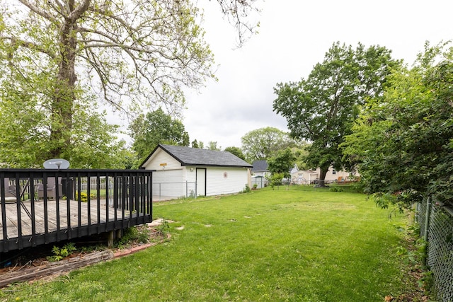 3919 69th St, Urbandale, IA 50322 - view of yard with a detached garage, a wooden deck, and an outdoor structure