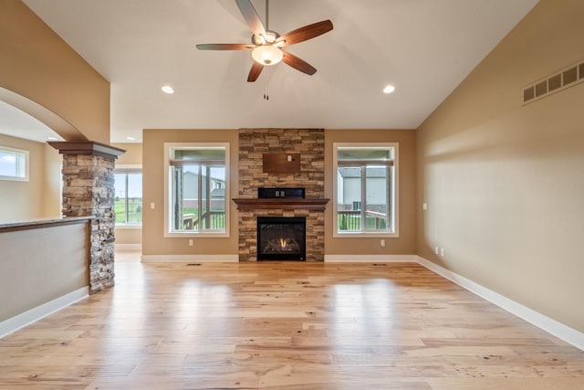 916 NE Silkwood St, Grimes, IA 50111 - unfurnished living room with a ceiling fan, light wood finished floors, a fireplace, vaulted ceiling, and baseboards