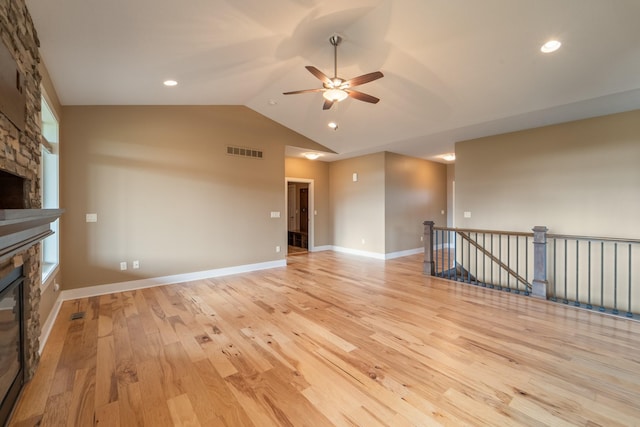 916 NE Silkwood St, Grimes, IA 50111 - unfurnished living room with a stone fireplace, ceiling fan, light wood finished floors, lofted ceiling, and recessed lighting