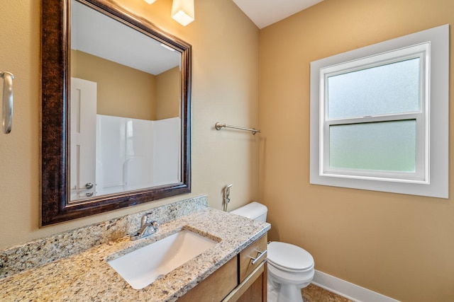 916 NE Silkwood St, Grimes, IA 50111 - bathroom with toilet, vanity, and baseboards