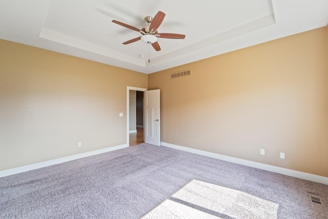 916 NE Silkwood St, Grimes, IA 50111 - empty room with a raised ceiling, carpet, a ceiling fan, and baseboards